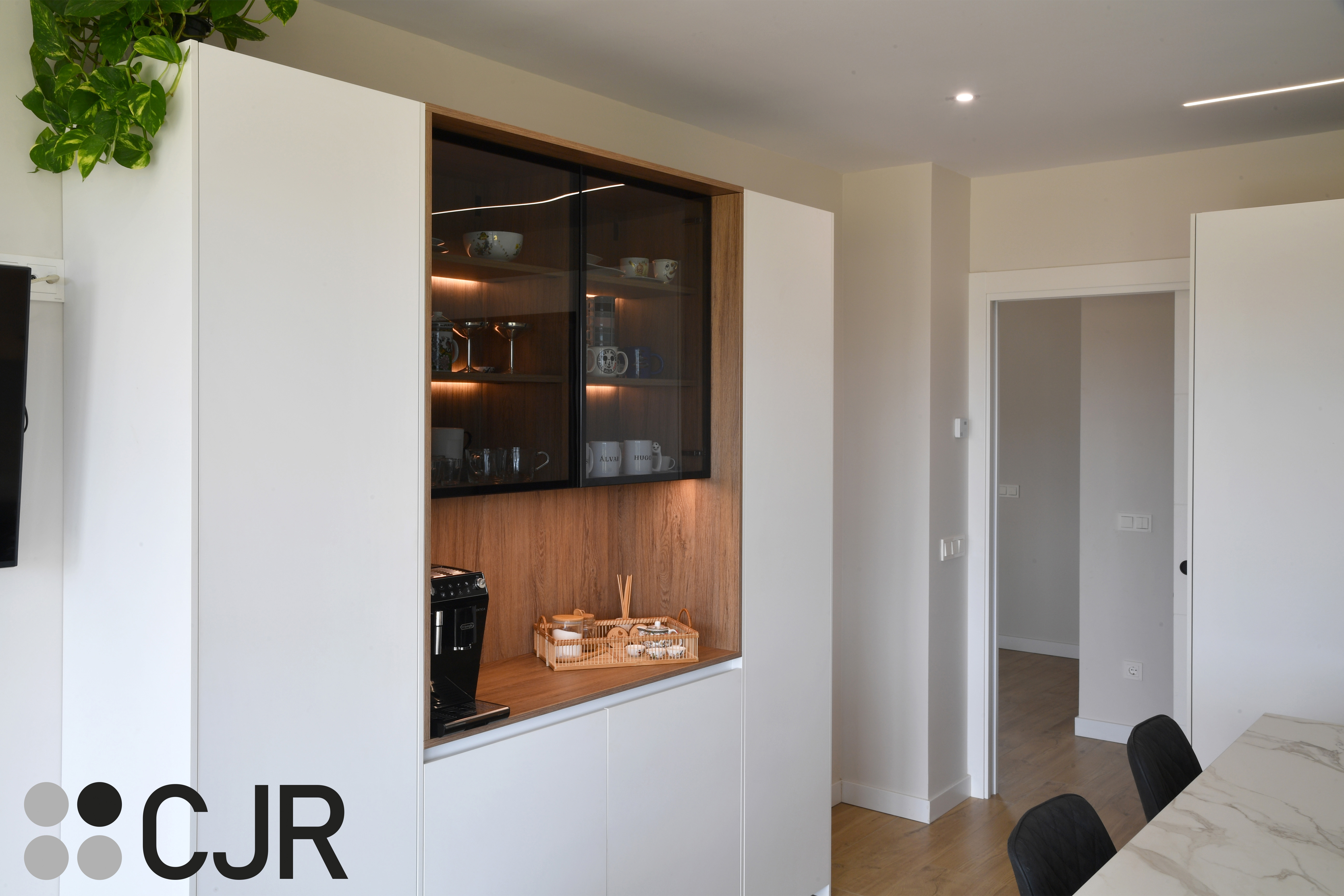 Cocina moderna blanca y madera con isla central y mesa Cocinas CJR