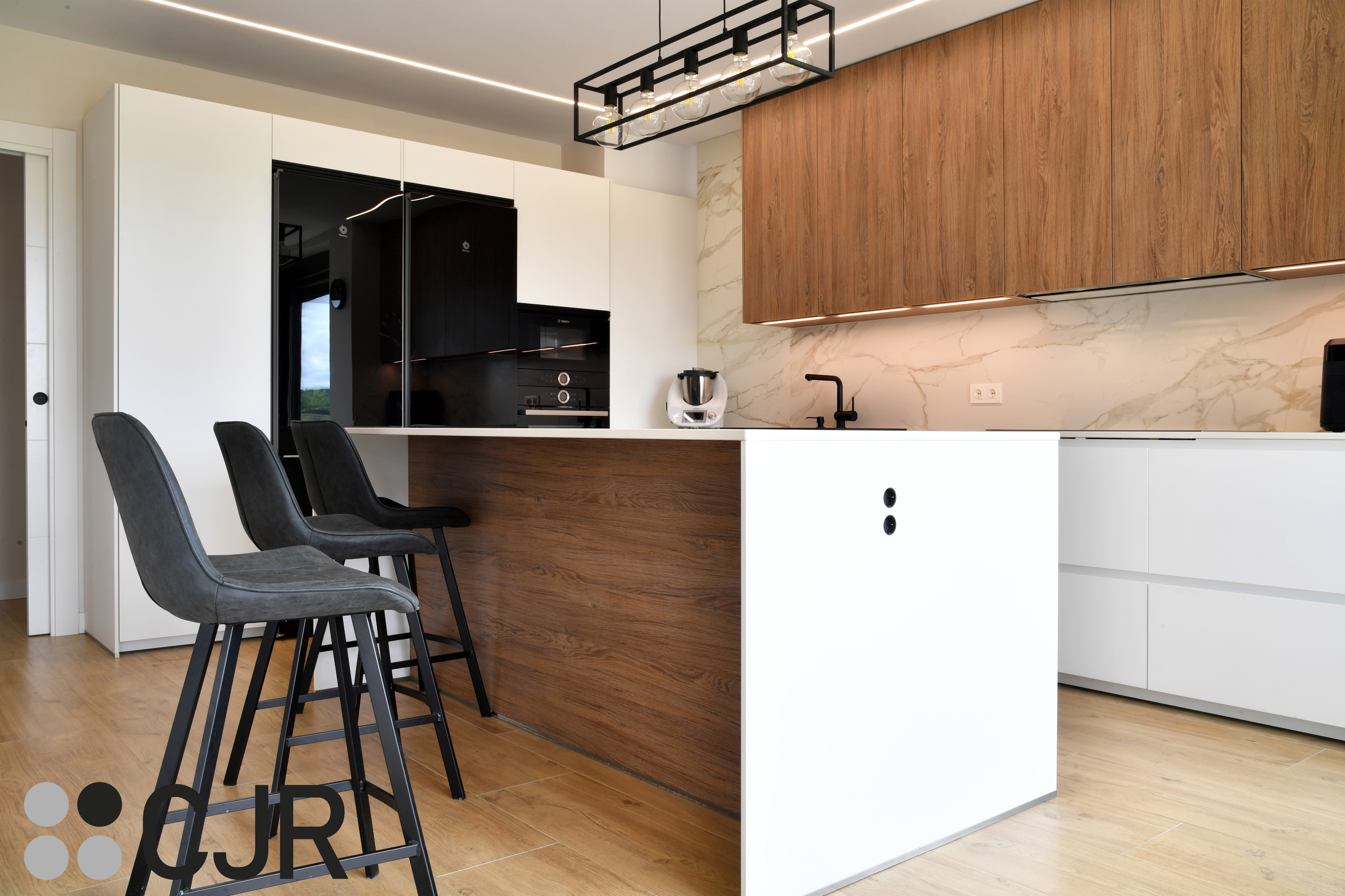 Cocina moderna blanca y madera con isla central y mesa Cocinas CJR