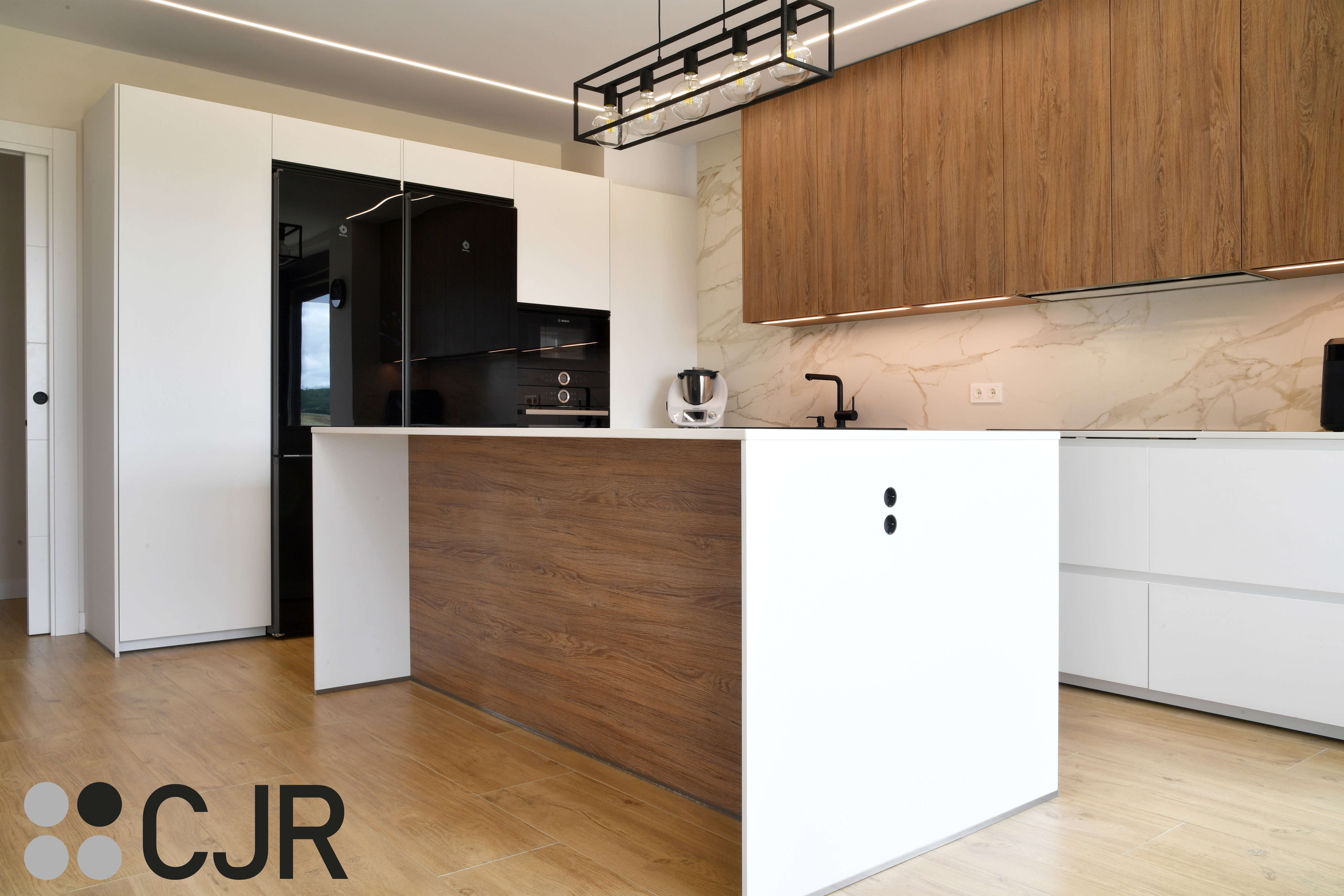 Cocina moderna blanca y madera con isla central y mesa Cocinas CJR