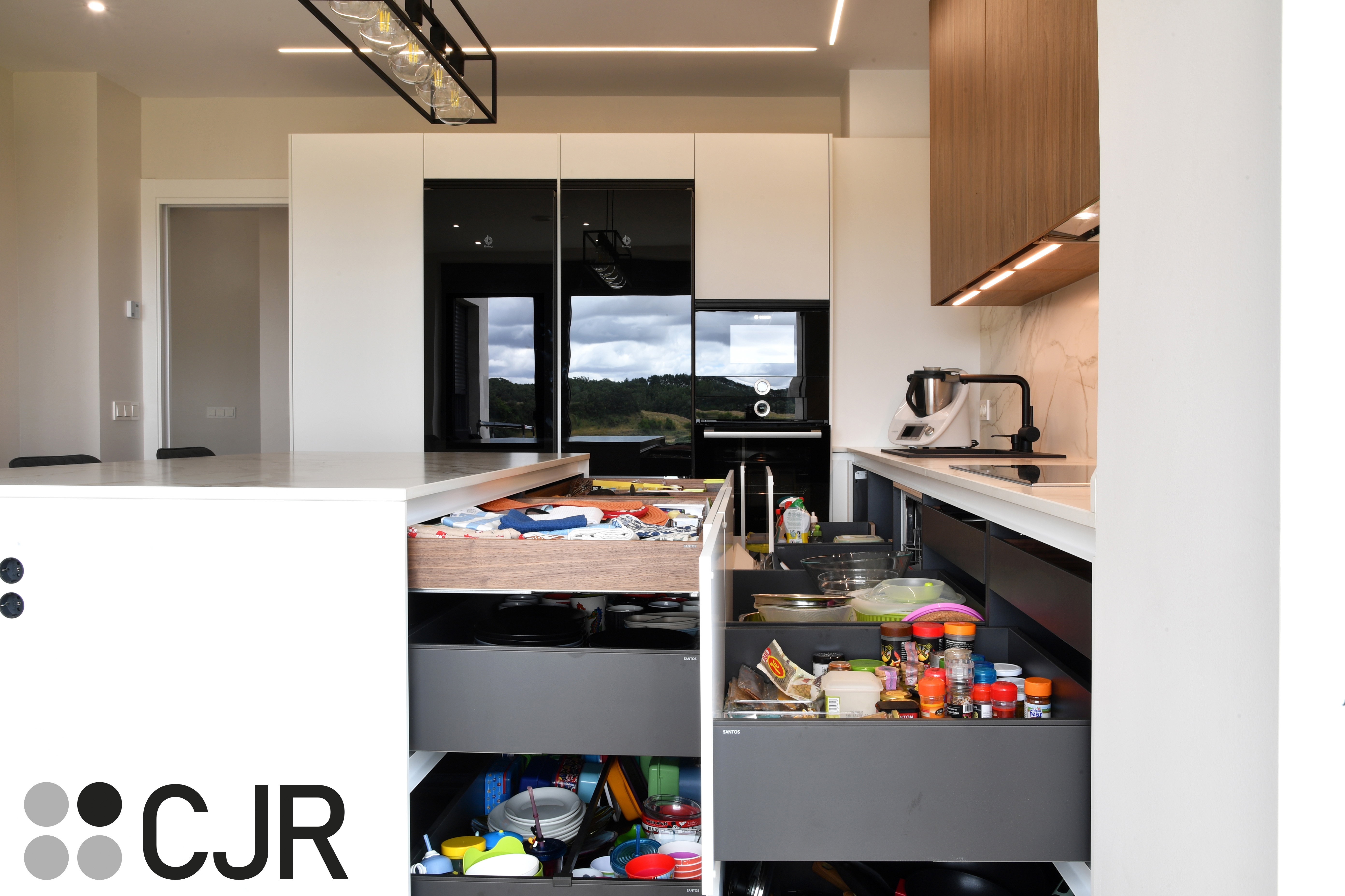 Cocina moderna blanca y madera con isla central y mesa Cocinas CJR