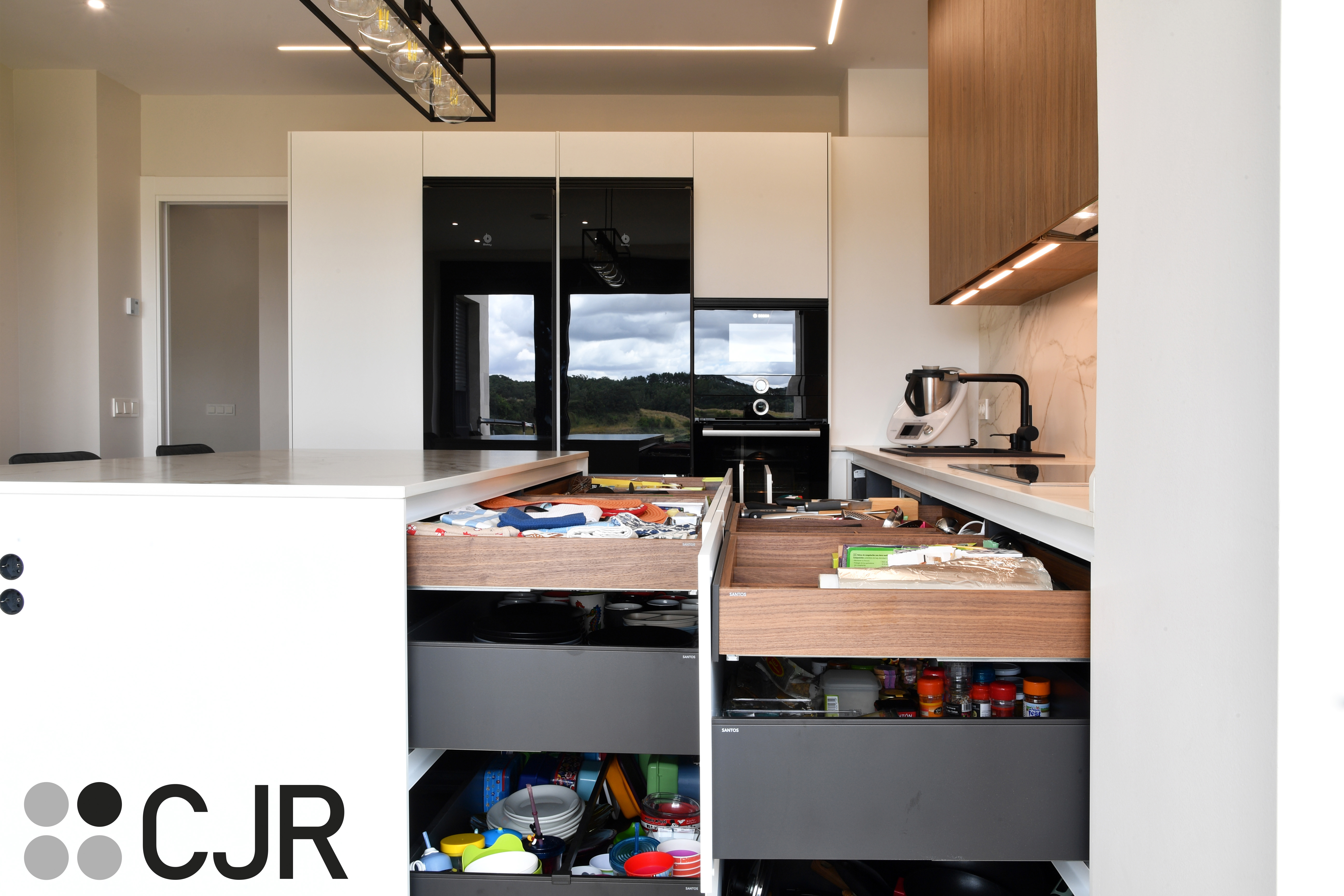 Cocina moderna blanca y madera con isla central y mesa Cocinas CJR