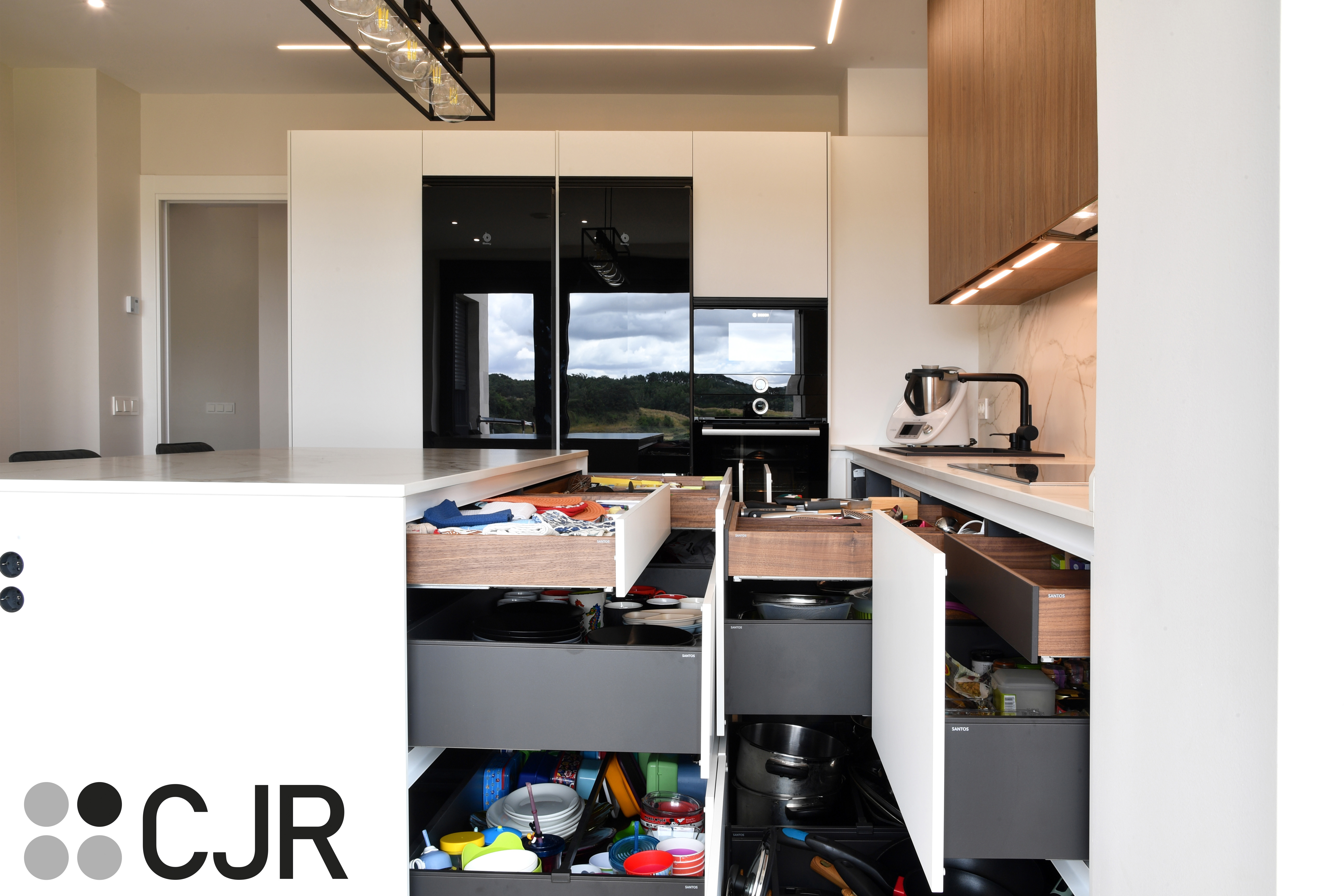 Cocina moderna blanca y madera con isla central y mesa Cocinas CJR