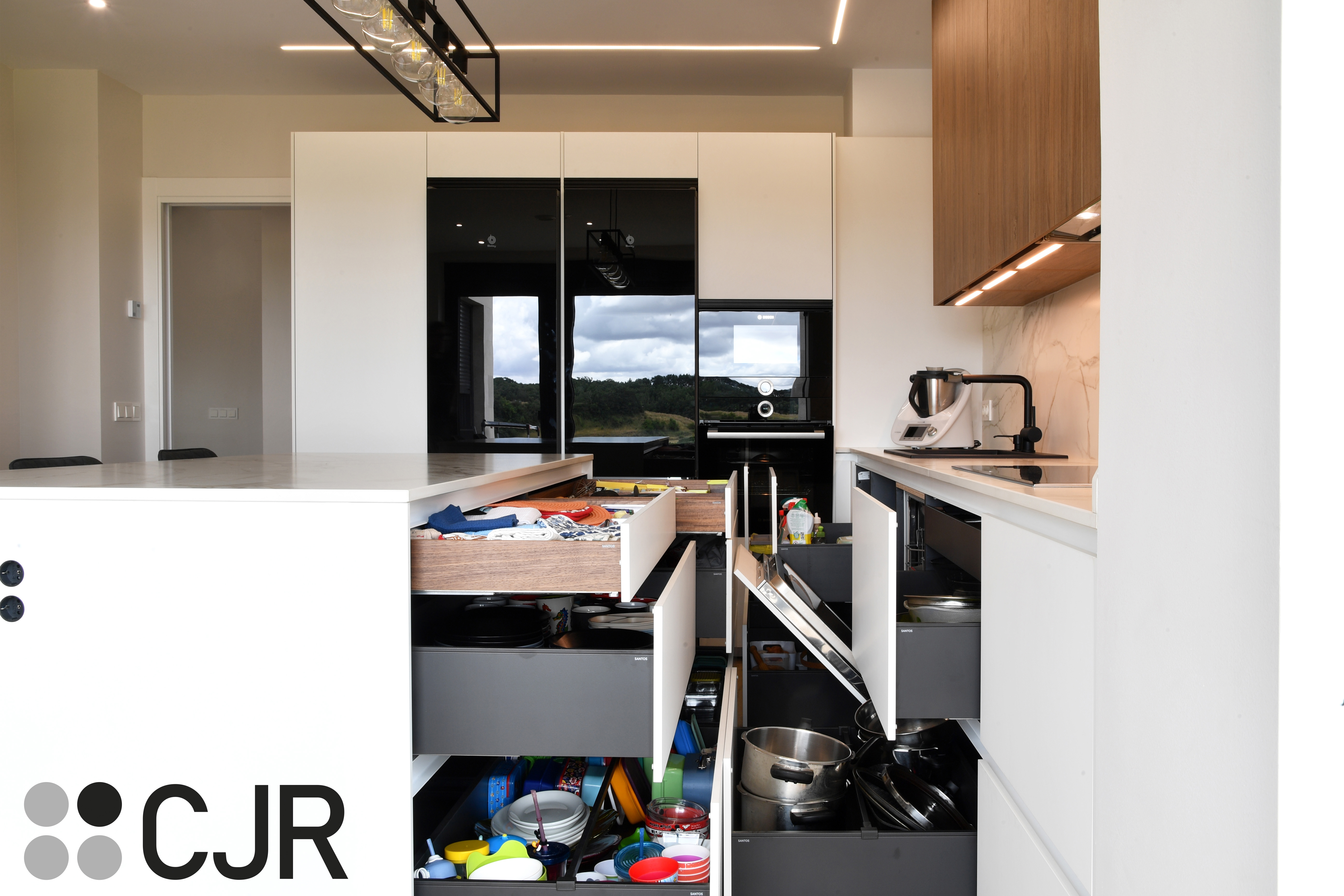 Cocina moderna blanca y madera con isla central y mesa Cocinas CJR