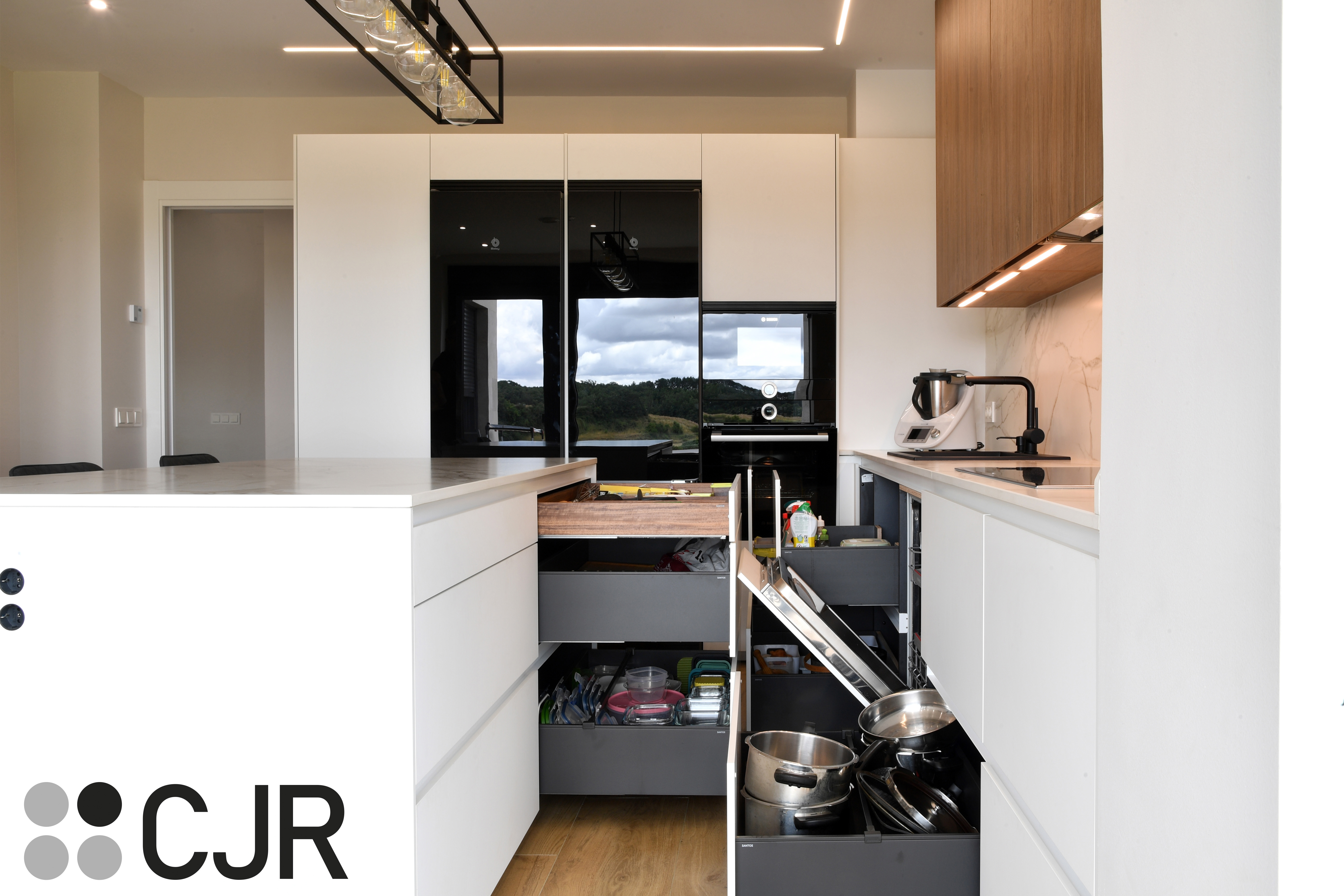 Cocina moderna blanca y madera con isla central y mesa Cocinas CJR