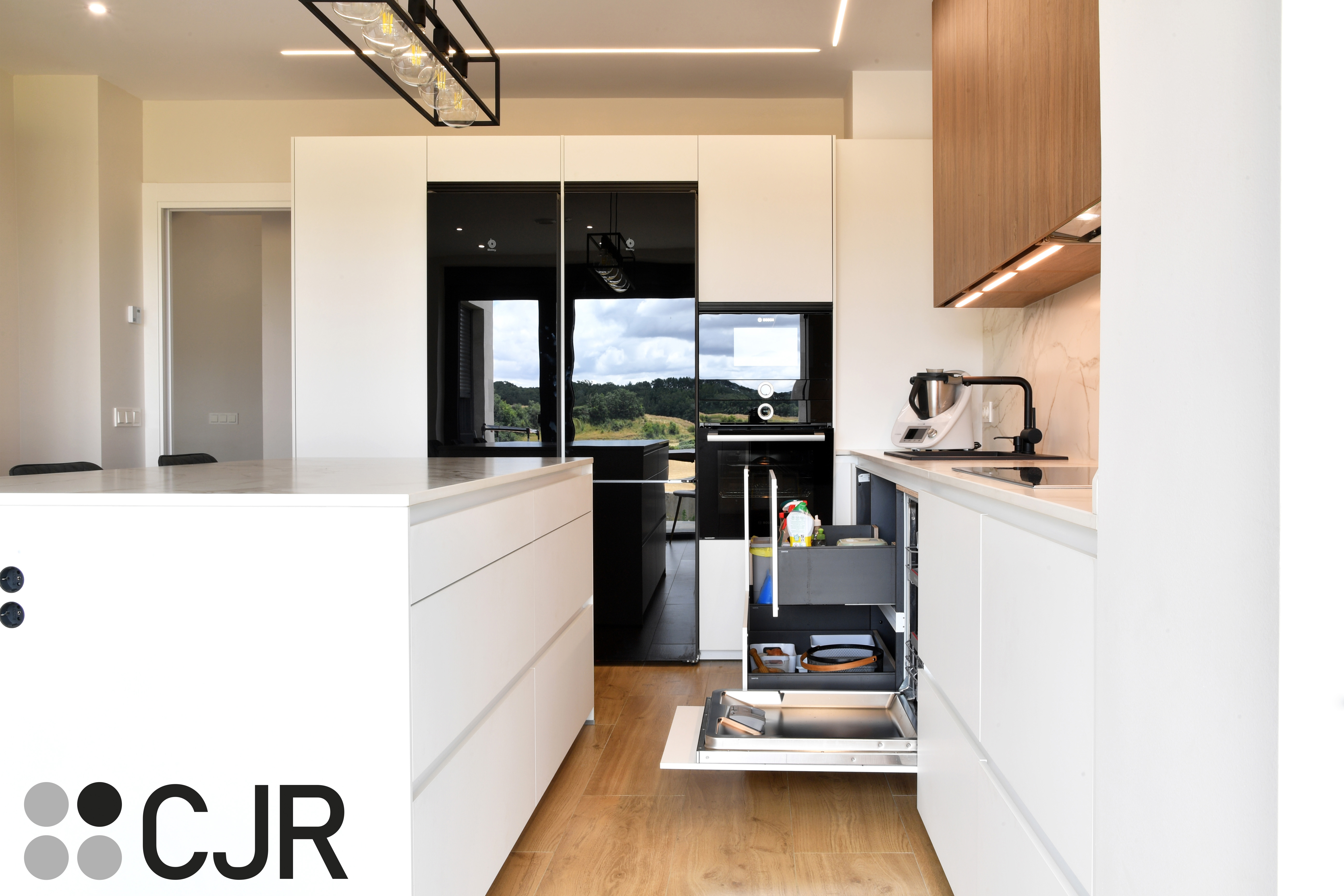 Cocina moderna blanca y madera con isla central y mesa Cocinas CJR