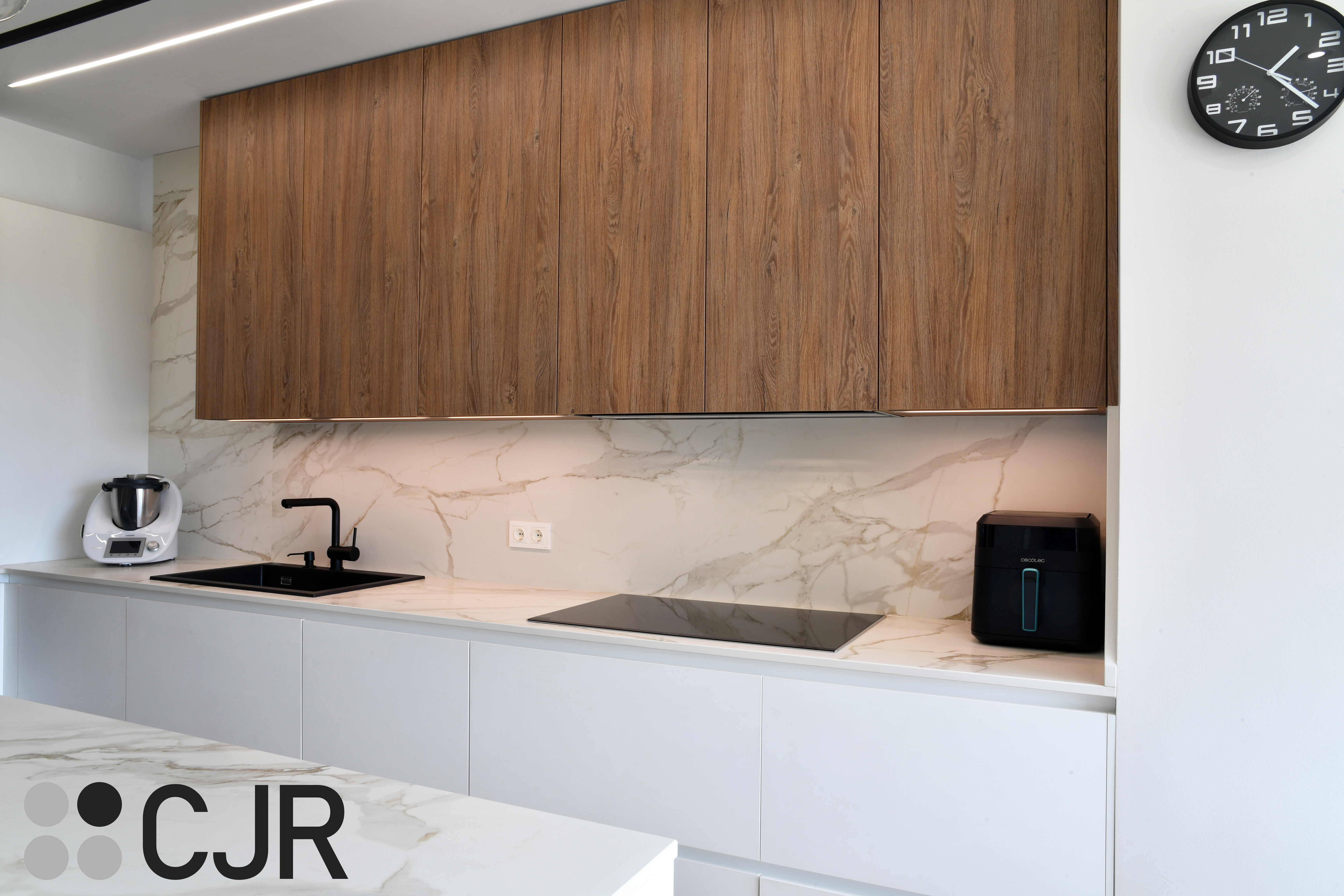 Cocina moderna blanca y madera con isla central y mesa Cocinas CJR