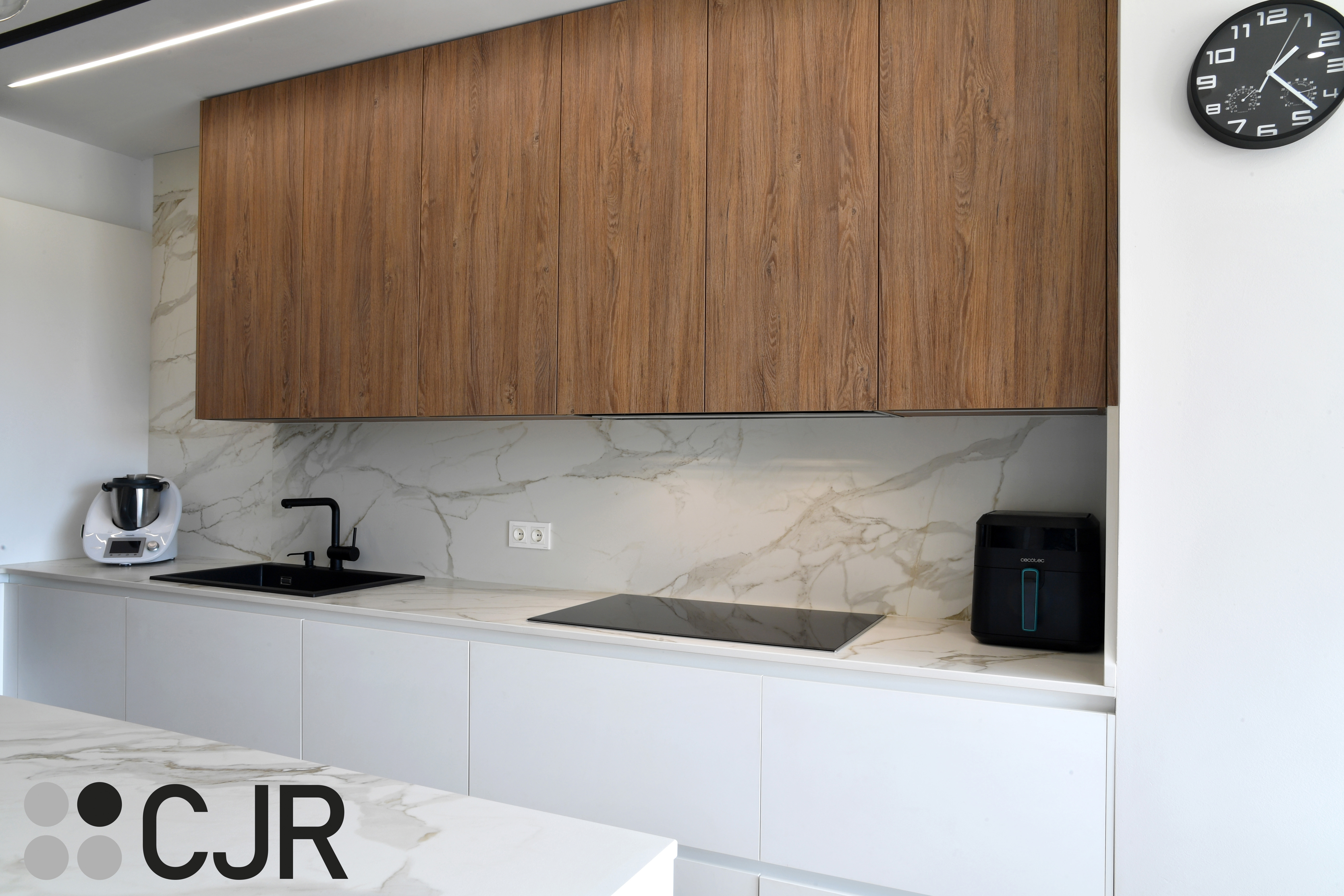 Cocina moderna blanca y madera con isla central y mesa Cocinas CJR