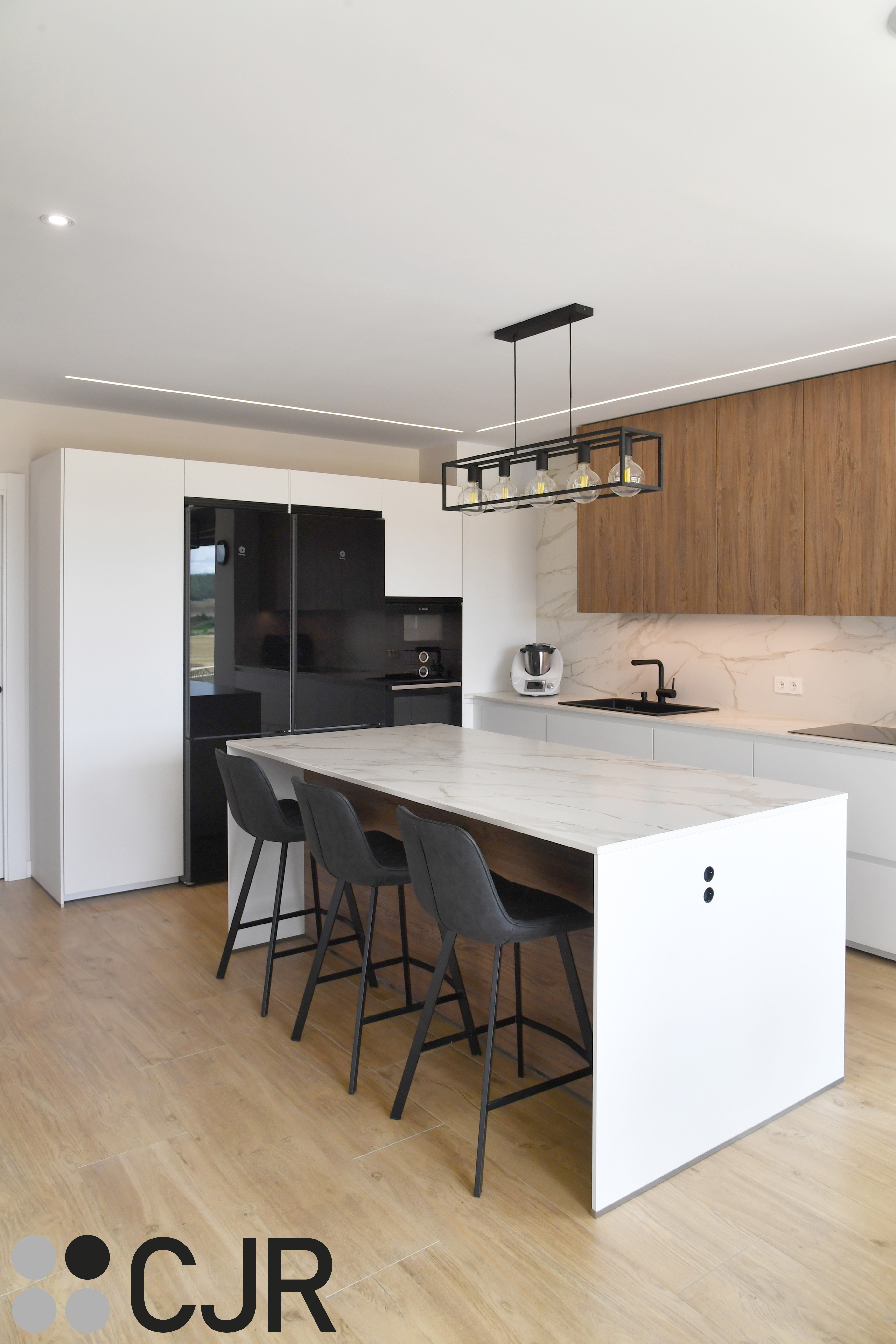 Cocina moderna blanca y madera con isla central y mesa Cocinas CJR