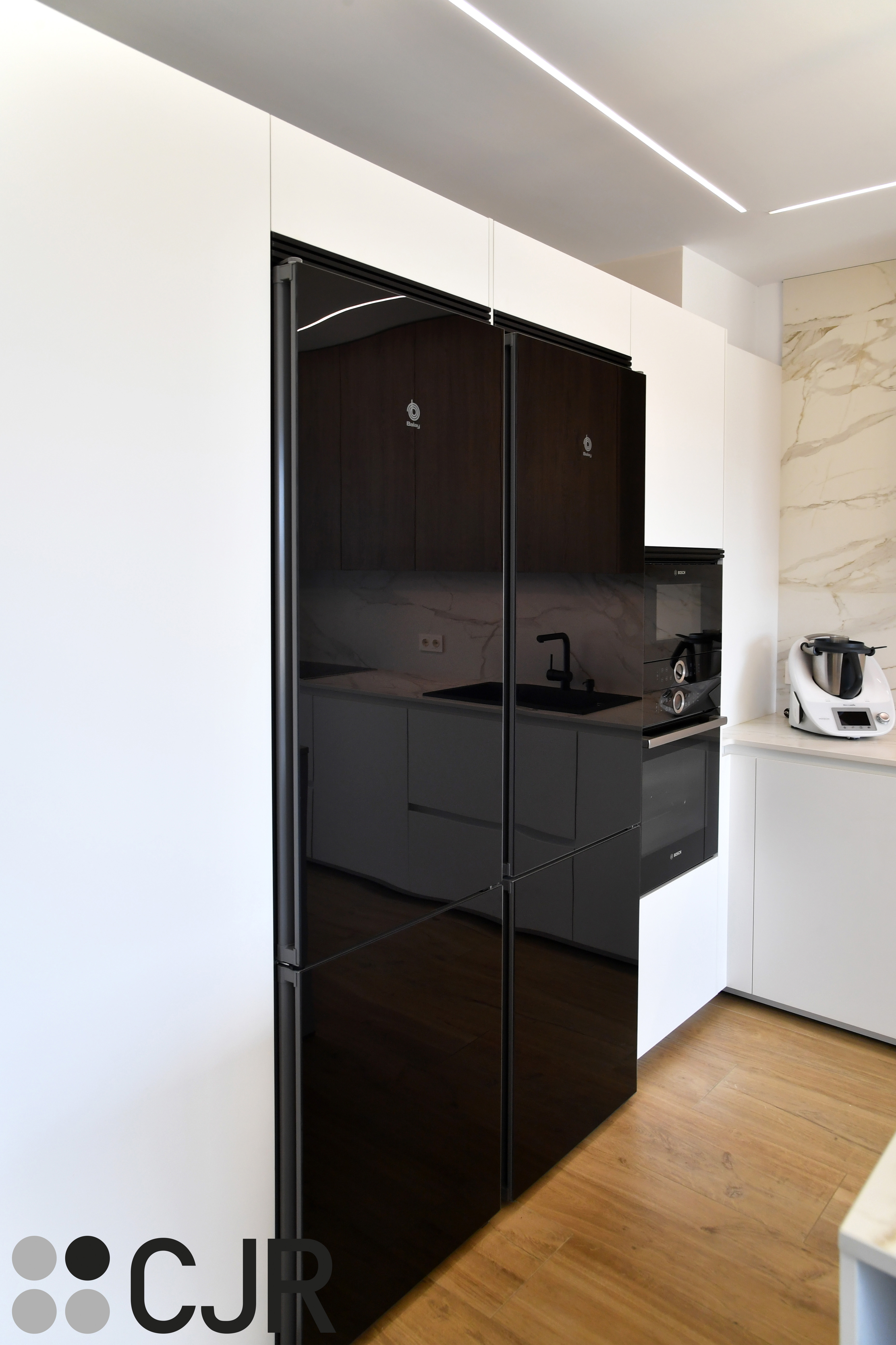 Cocina moderna blanca y madera con isla central y mesa Cocinas CJR