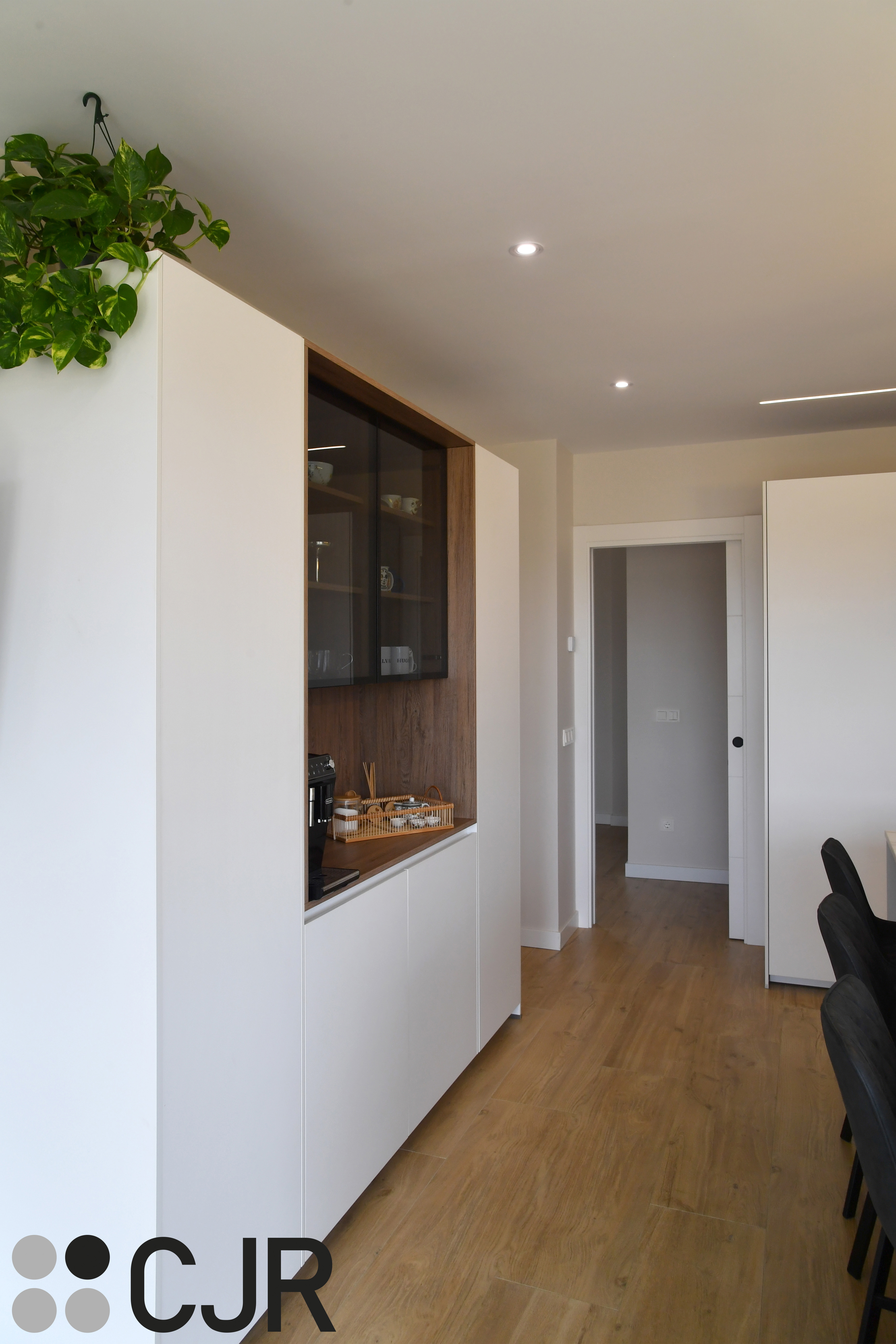 Cocina moderna blanca y madera con isla central y mesa Cocinas CJR