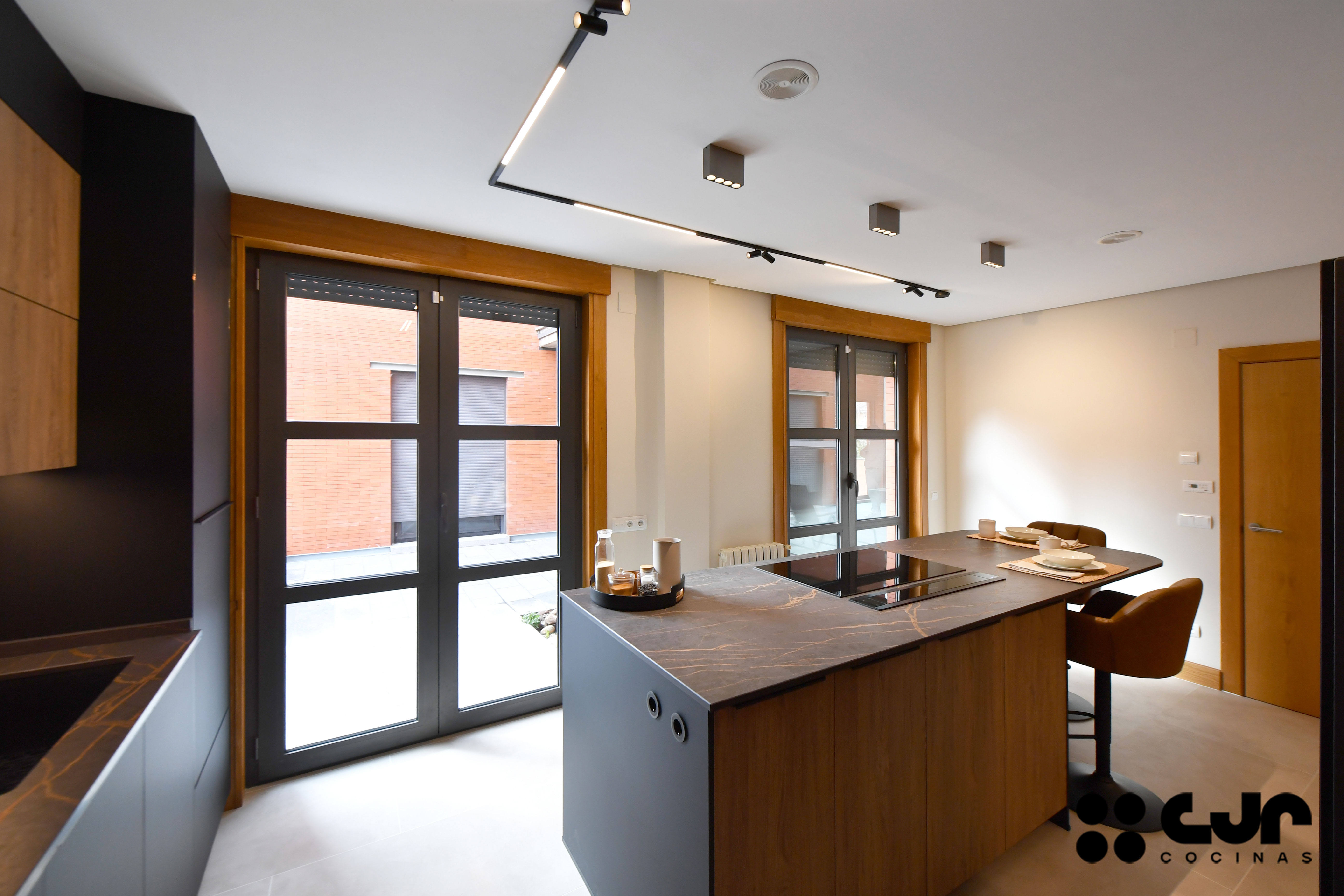 cocina negra mate y madera con isla Dekton Laurent cocinas cjr