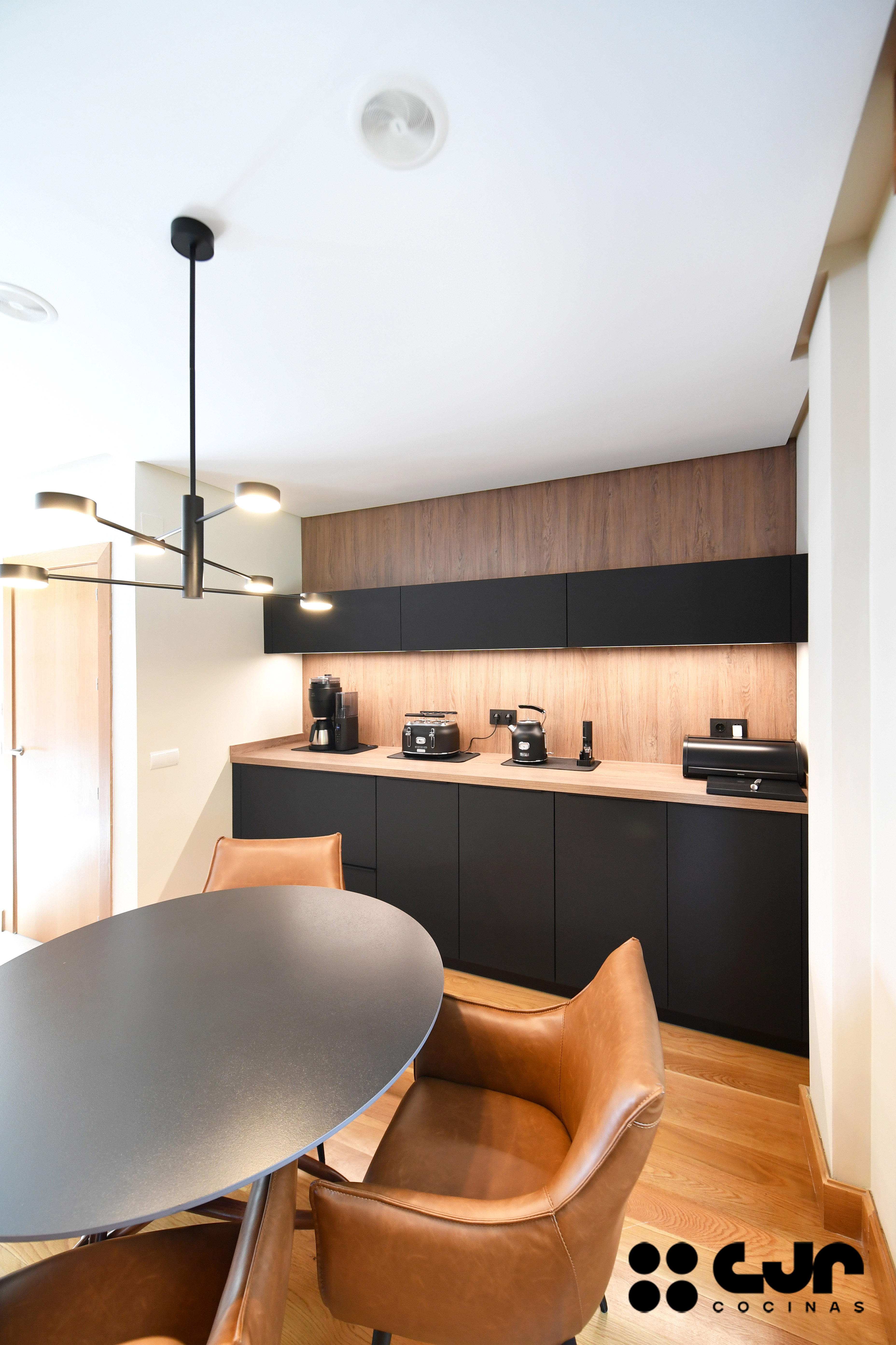 cocina negra mate y madera con isla Dekton Laurent cocinas cjr