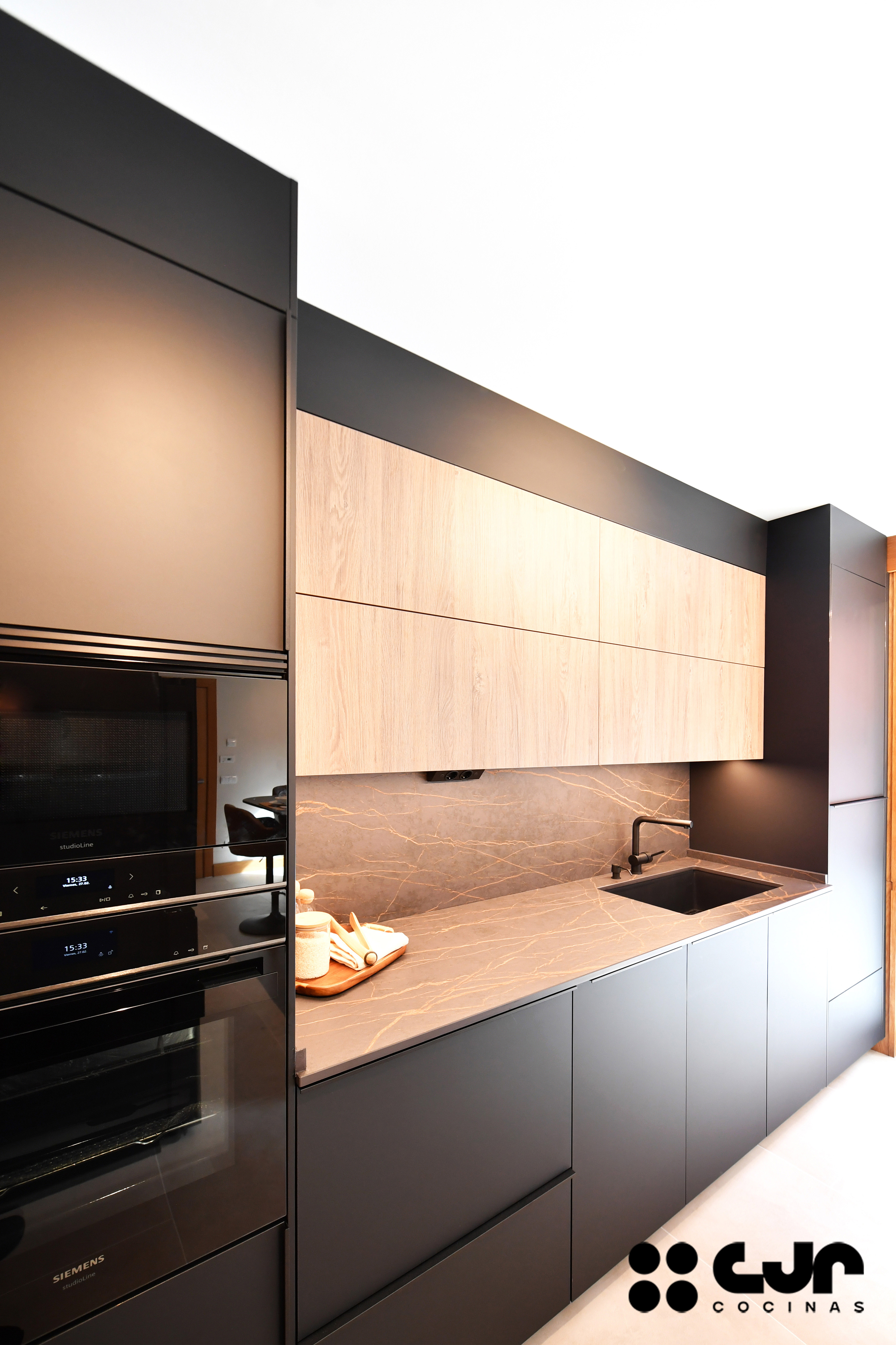 cocina negra mate y madera con isla Dekton Laurent cocinas cjr
