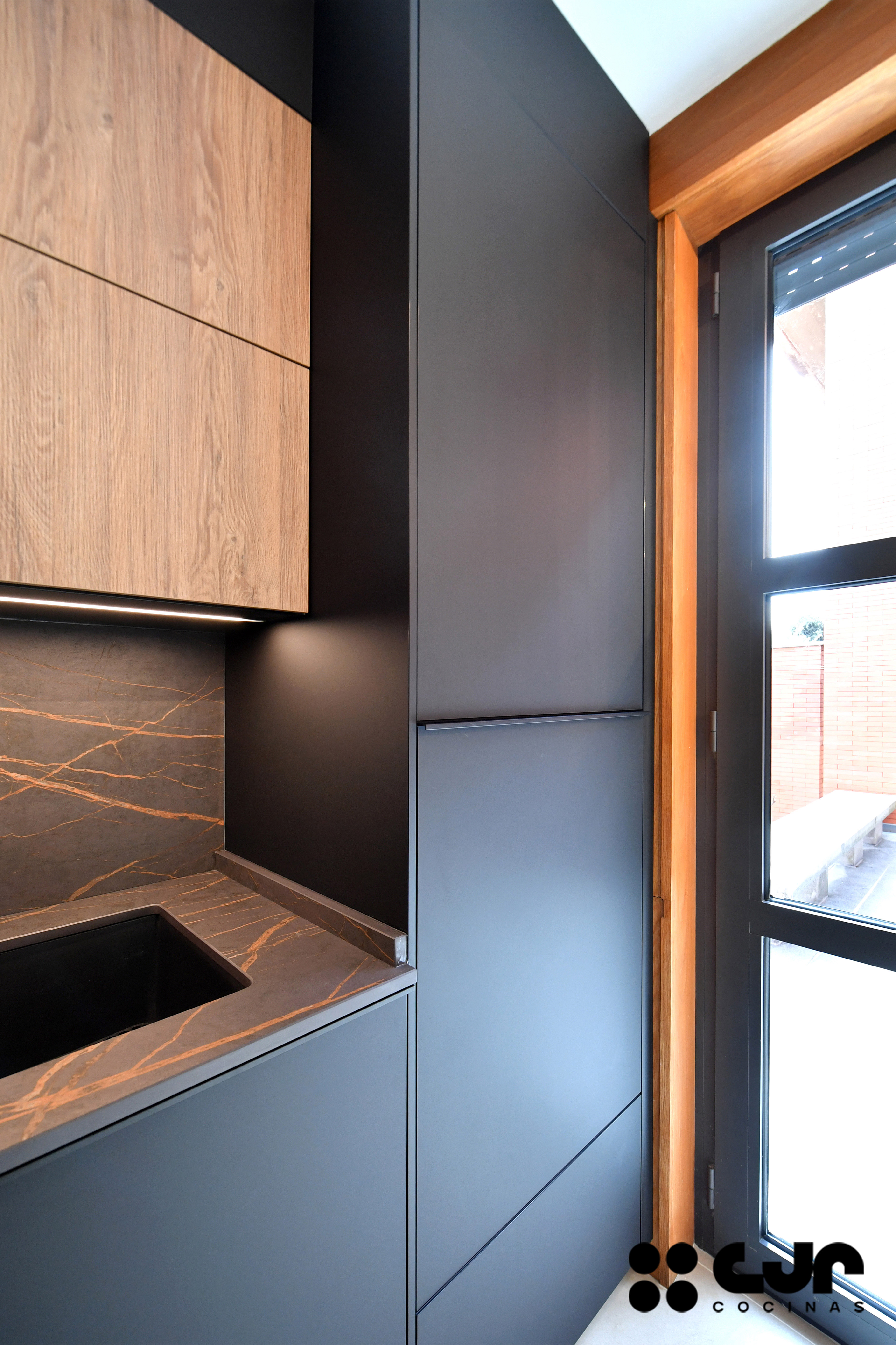 cocina negra mate y madera con isla Dekton Laurent cocinas cjr