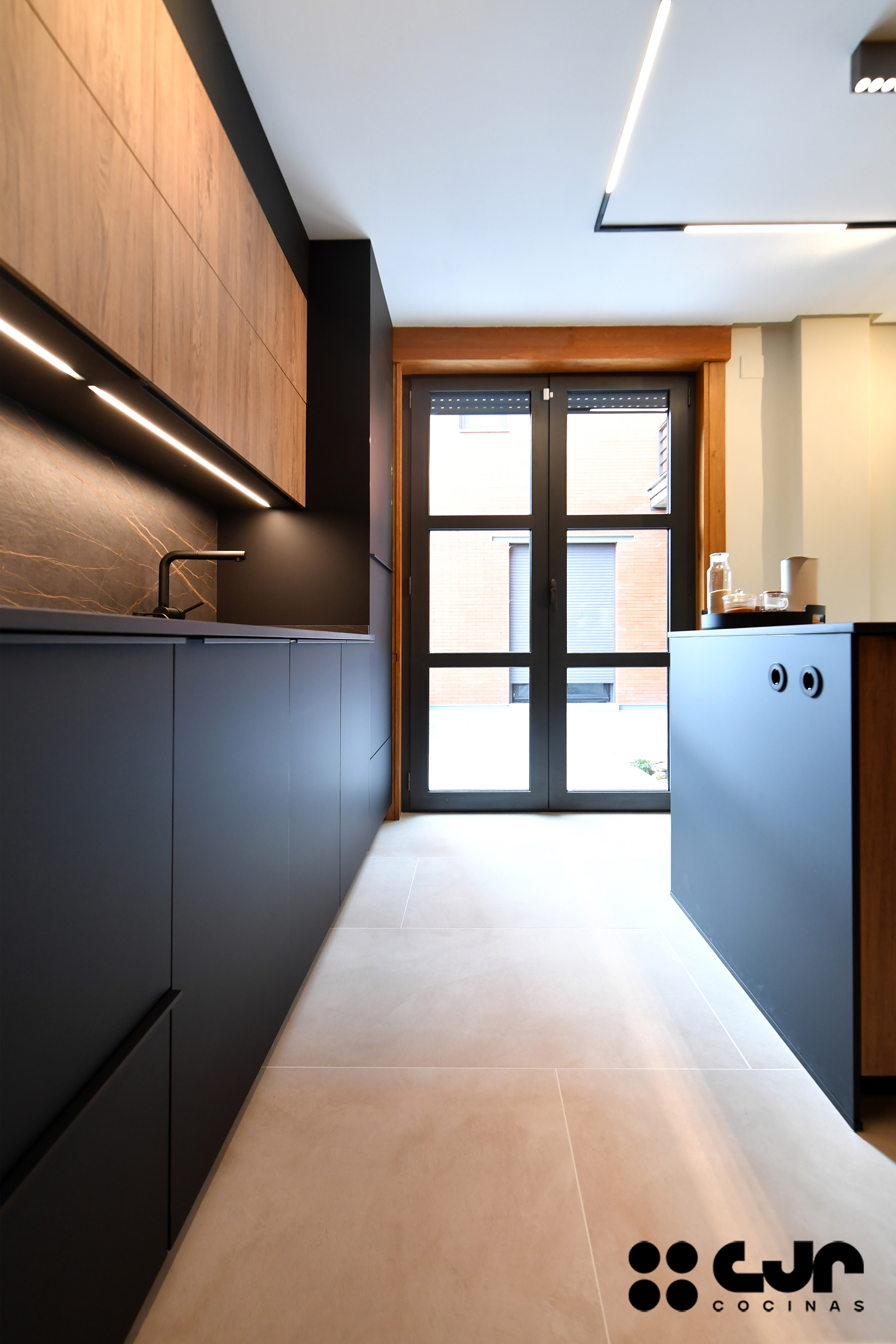 cocina negra mate y madera con isla Dekton Laurent cocinas cjr